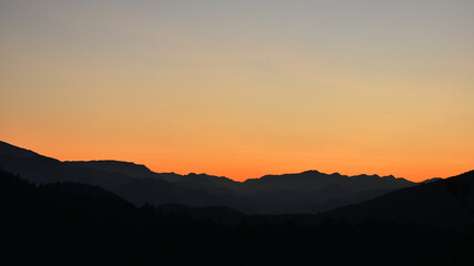 Abendrot über Berglandschaft und Hügelllandschaft bis zum Horizont, grau, orange in Niederösterreich, Österreich