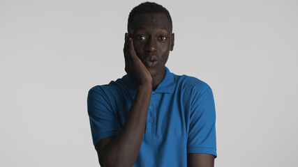 Handsome nice African American guy looking cute on camera over white background