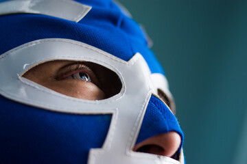 Close up of blue eyed man wearing  a blue wrestling mask