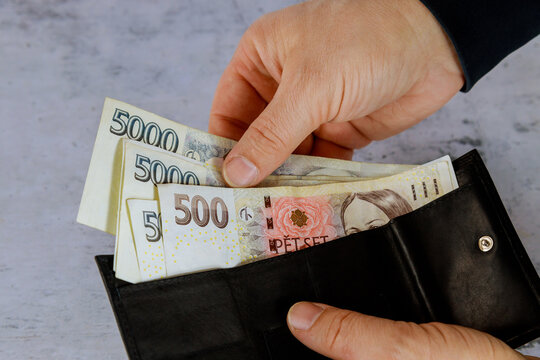 Man counts Czech korun in his wallet