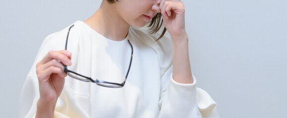 目の疲れ　眼精疲労　眉間を押さえる女性