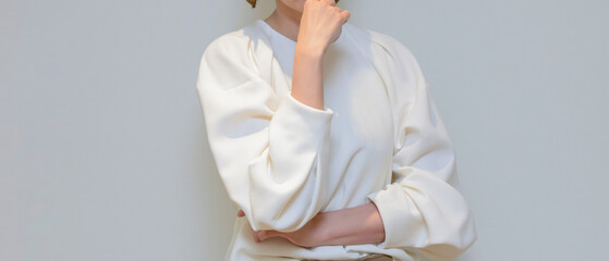 口元に手をあて、考えるポーズをする女性