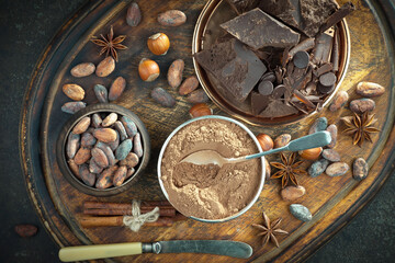 Fototapeta na wymiar Pieces of dark chocolate and cocoa beans in composition on old background