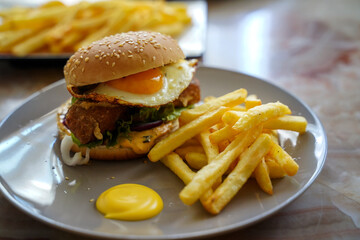 Homemade burger with egg, fries and cheese sauce