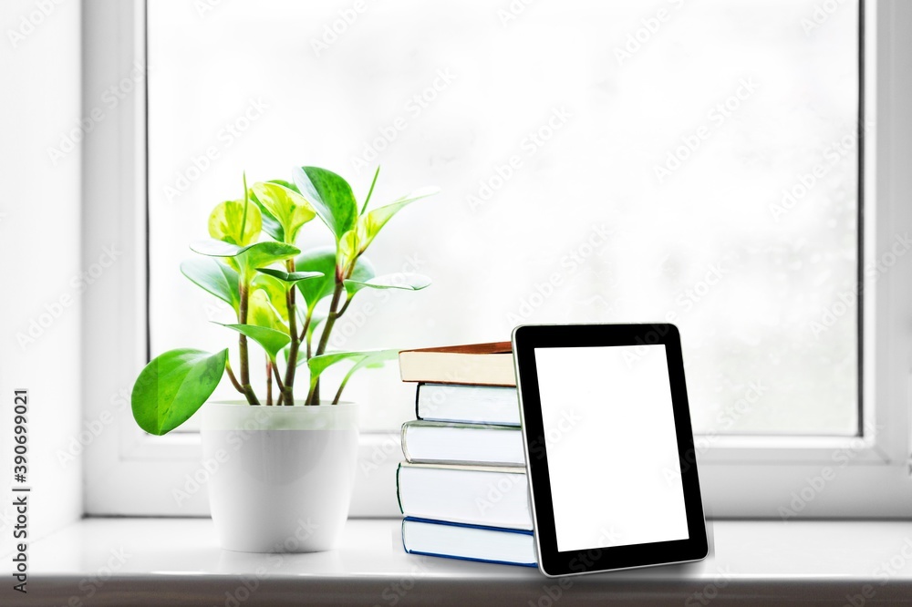 Poster stack of books with modern digital tablet on table