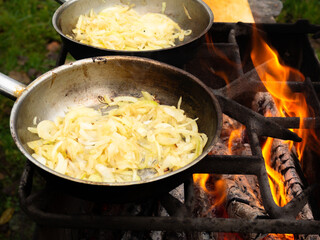 pans on the fire on the grill. roasting onions in the bright flames of the brazier.