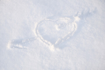 One heart in the snow. A heart is drawn on the snow close-up. The shape of heart on the snow. Winter background..