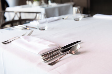 Dinner setting. Silver fork and knife on table. Restaurant interior