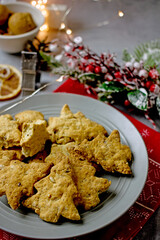 Homemade Christmas gluten-free cookies in the form of a Christmas tree and  stars on a gray plate close-up. Healthy festive diet baking concept