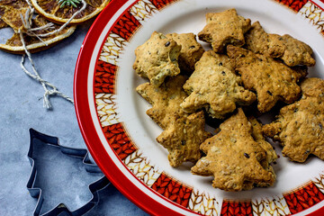 Homemade Christmas gluten-free cookies in the form of a Christmas tree and  stars on a gray plate close-up. Healthy festive diet baking concept