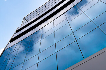 windows with reflection of clouds and blue sky in industrial and colorful business buildings