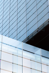 windows with reflection of clouds and blue sky in industrial and colorful business buildings
