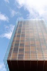 windows with reflection of clouds and blue sky in industrial and colorful business buildings