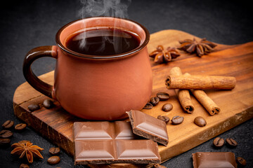 Cup of coffee , coffee beans, chocolate  and cinnamon on black background