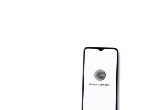 Lod, Israel - July 8, 2020: Google Authenticator app launch screen with logo on the display of a black mobile smartphone isolated on white background. Top view flat lay with copy space.