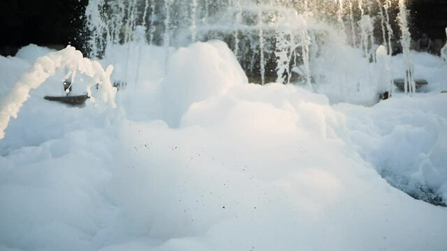 Huge amount of foam in the fountain. The prankster added shampoo to the fountain. Washing the fountain