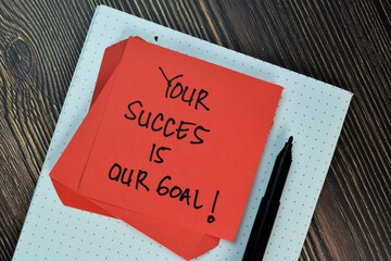 Your Success is Our Goal! write on sticky note isolated on Wooden Table. Motivation/Inspiration concept