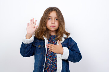 Little caucasian girl with beautiful blue eyes wearing denim jacket standing over isolated white...