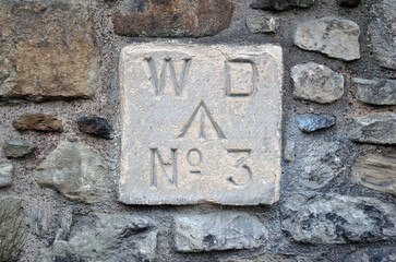 Old Stone Marker Plaque on Exterior Wall 'WD  No 3' and Small Arrow 