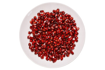 Ripe pomegranate grains in a white plate isolated on a white background. Top view, flat lay.