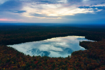 Aerial view of the lake in the forest at sunset