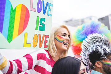 Girl holding a banner at a gay pride parade - Lesbian woman having fun at fest event - Lgbt and love concept - Focus on woman face