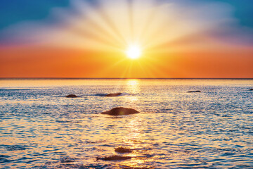 Fototapeta na wymiar Sunset sea with rocks and evening sunset sun on dramatic sky