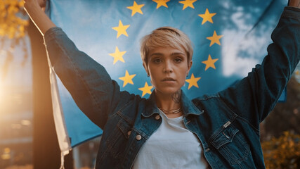 Obraz na płótnie Canvas Young caucasian woman holding European union flag in the park. High quality photo