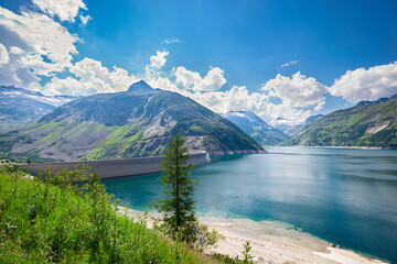 Wide angle view of dam in reservoir lake Kölnbreinspeicher and surrounding mountains in state of Carinthia, Austria