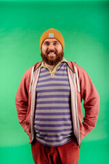 Portrait of a bright man posing in the studio on a green background. Men, beauty, colors, fashion.