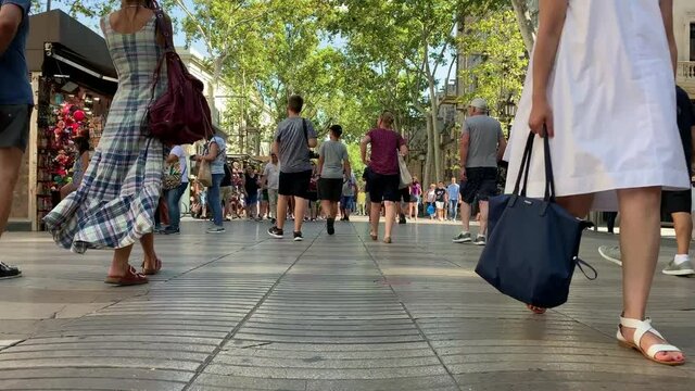 Time lapse footage of people walking on one of the most famous streets called "La Rambla" in Barcelona. It is a sunny summer day.