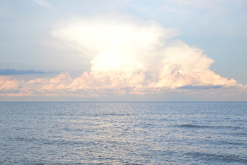 Naklejka na ściany i meble Sunset behind the clouds on the sea in summer