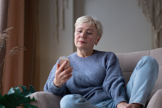 Senior woman waiting for a phone call at home