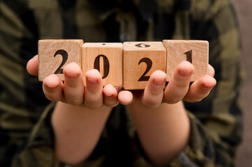 Happy new year 2021 Christmas and New Year background. Symbol from number. Wooden cubes on hands.