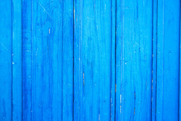Wooden protection on all background, is painted light blue. old cracked blue paint on wood flooring.