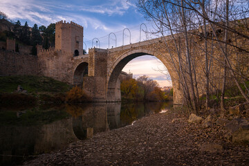 The famous Alcantara bridge over Tagus river in the medieval city of Toledo at sunset, Spain