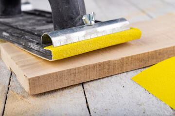 Sanding wood with sandpaper. Carpentry accessories for precise woodworking.