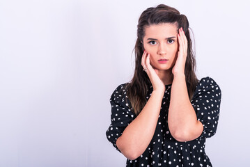 a beautiful young girl posing in a short black and white dress on a white background