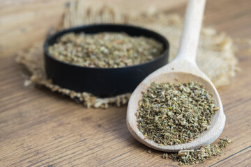 Dry, finely ground cistus leaves, herbal tea on wooden spoon