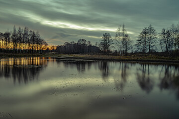 Fototapeta na wymiar Evening sunset on a forest lake