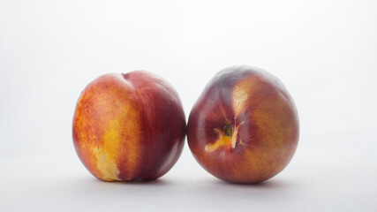 Fresh juicy peaches on a white plate. Close-up Fresh organic peaches nectarine on a white plate.