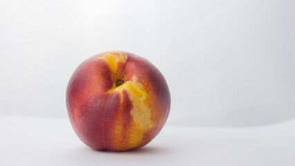 Fresh juicy peaches on a white plate. Close-up Fresh organic peaches nectarine on a white plate.