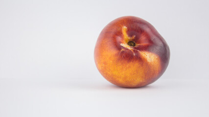 Fresh juicy peaches on a white plate. Close-up Fresh organic peaches nectarine on a white plate.