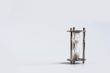 Hourglass on white background with copy space, Sand flowing through the bulb of Sandglass measuring the passing time. countdown, deadline, Life time and Retirement concept