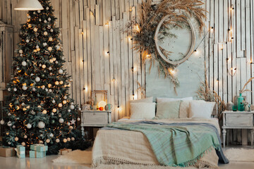 Big beautiful New Year tree with gifts in a white decorated bedroom for the New Year. 