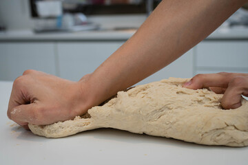 manos amasan pan fresco artesanal con levadura harina agua sobre base blanca cordoba argentina