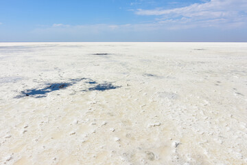Fototapeta na wymiar Landscape of a deserted salt lake. The texture of salt formations in the foreground. salt lake surface, dry salt lake, white salt lake