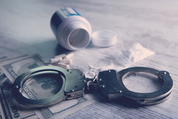 Drugs and handcuffs composition. Selective focus. Crime concept. Illegal money.