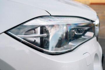 Premium of a modern car,  white executive car, with beautiful wheels, large chrome grille.