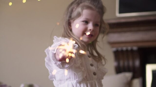 Little girl holding sparklers. Child and fireworks. A party. High quality FullHD footage